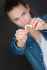 a girl is breaking cigarette