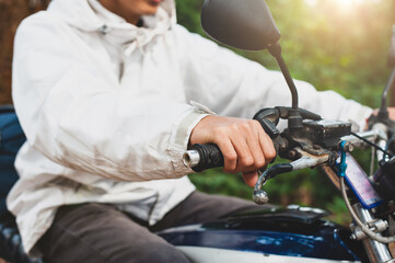 Close-up a young man holding a motorcycle handlebar driving a motorcycle.
