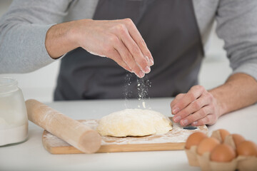 close up of hands kneading dough on a table