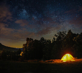 Fototapeta na wymiar A camping tent under milky way sky and twilight at night