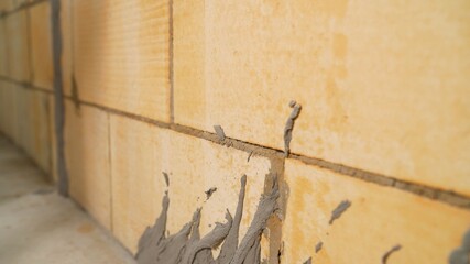 A worker plasters the wall and applies a cement mortar. Applying the solution to the wall.