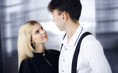 Young couple of businessman and woman are standing in a modern office. Portrait of successful business people