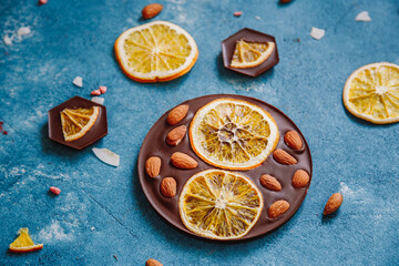 Diet dark chocolate without sugar based on cocoa and stevia with the addition of freeze-dried berries, nuts and fruits. Top view on blue background