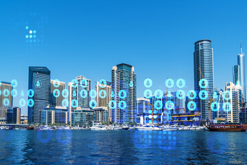 Fototapeta premium Skyscrapers of Dubai business downtown. International hub of trading and financial services. Social network icons hologram, concept of human resources. Double exposure. Dubai Canal waterfront.