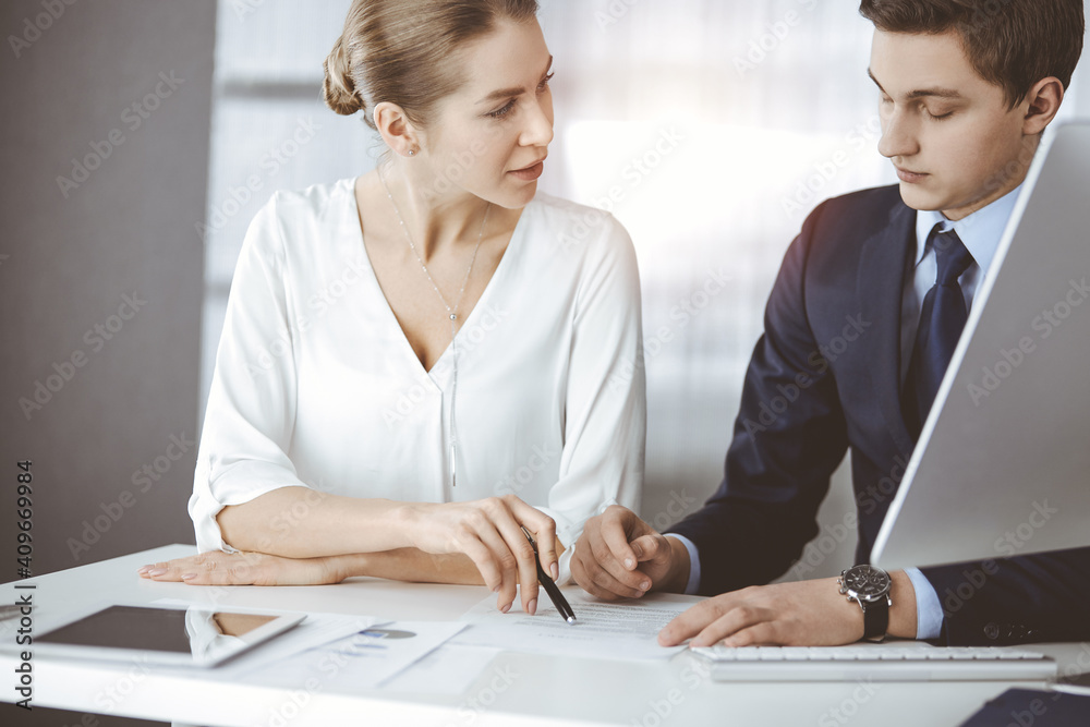 Wall mural business people discussing something while sitting in sunny office. focus at businesswoman while tal