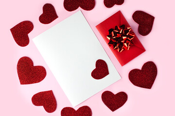 Blank sheet of paper with copy space and red envelope on the pink background. Concept for Valentin's day. Place for text.