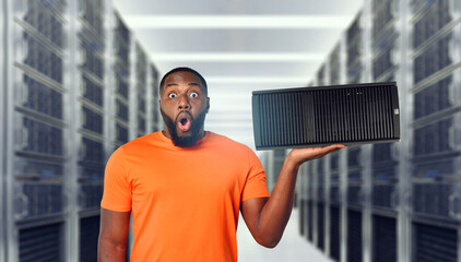Surprised black man holds a server in hand. Concept of hosting and storage