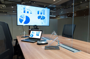 Video conference meeting room with clear acrylic sheet separates the center on the conference table to prevent COVID-19 and face shield on the table.  - obrazy, fototapety, plakaty