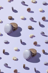 Macaroon patern of different sizes, chocolate, coconut and berry cookies on a lilac, purple background