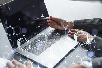 Two information technology specialist brainstorming on project to create a new approach to develop software to improve business service. Working with laptop. Tech hologram icons.