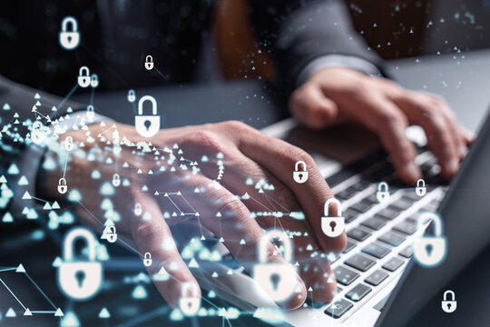 A programmer is typing a code on computer to protect a cyber security from hacker attacks and save clients confidential data. Padlock Hologram icons over the typing hands. Formal wear.