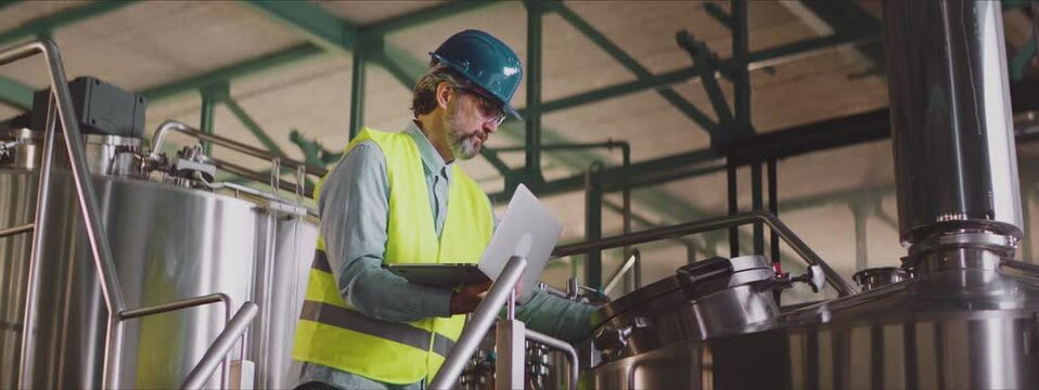 Process engineer adjusting settings of industrial equipment. Chemical or food production process control concept.