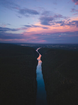 Silhouette of person standing on cliff during sunset