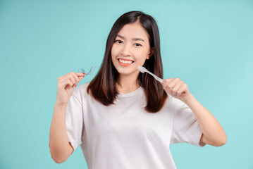 Dental Beautiful smiling of young asian woman with retainer braces and toothbrush for white teeth increase confidence for healthy on blue background isolated, Happiness teenager facial expression.