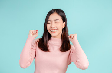 Dental braces of young asian woman wearing retainer braces glad emotion with white teeth increase confidence for healthy on blue background isolated, Happiness teenager smiling facial expression.