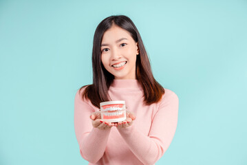 Dental of asian woman with tooth sample and white teeth increase confidence for healthy on blue background isolated studio shot, Happiness teenager smiling facial expression.