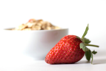 strawberry and a bowl of granola isolated against white background. Horizontal image