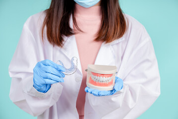 Asian dentists are teaching them how to care for oral and dental care, including after correct orthodontic treatment on blue background isolated studio shot.