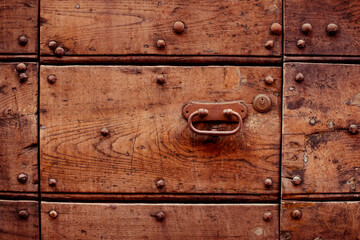 Fototapeta premium beautiful metal handle on a wooden door. beautiful retro doors. metal decoration on the door. wooden carved doors