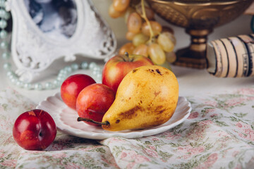 Seasonal fruits pears and plums in a rustic plate