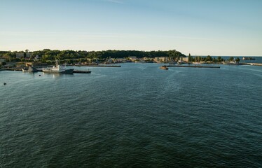 View from the ship to the port of Gdynia. Ships moored to the shore. Calm, blue water of Baltic Sea.