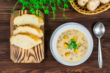 Homemade vegetarian mushroom soup with vegetables and bread in white plate