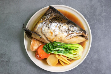 Salmon head soup soy sauce (Salmon Kabutoni) with pak chai, carrot, radish and ginger. Top view on...