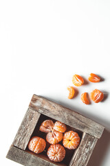 tangerines with fresh leaves in wooden box isolated on white, isolated on a white, top view
