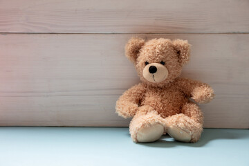 Teddy bear sitting on blue floor, child room