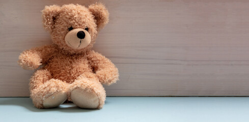 Teddy bear sitting on blue floor, child room, nursery