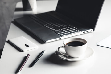 Business man using laptop computer with pen glasses and cup of hot coffee