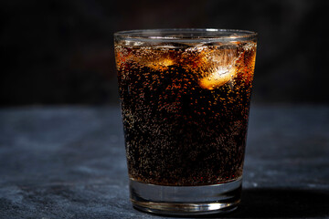 glass of coca cola with ice on a dark background