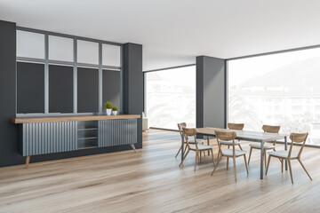 Grey and wooden living room with chairs and table, window with palms