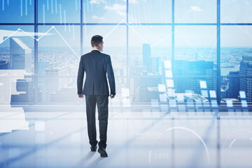 Fototapeta premium Man walking in panoramic office with graphs and cityscape