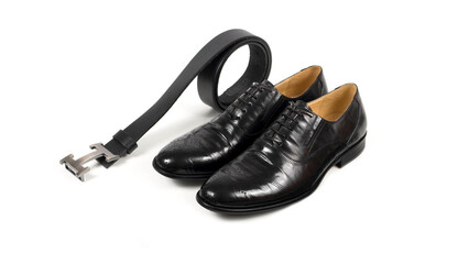 Close up of modern man accessories. Bordeaux bow tie, leather shoes, belt on white  background. Set for formal style of wearing isolated on white background..