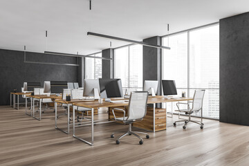 Wooden office room with armchairs and computers on the tables near window