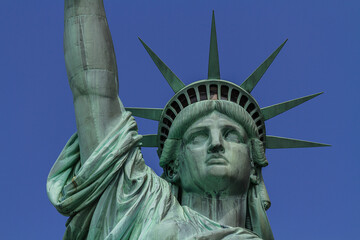 Close up view of the head of the Statue of Liberty with the crown and with the blue sky in the...