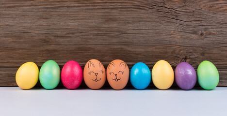 Colorful pastel easter eggs on wooden board background.