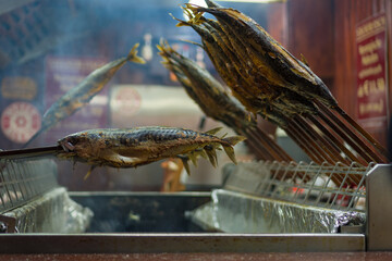Gegrillter Fisch auf Spießen auf Volksfest in Bude