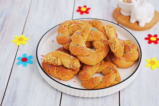 Traditional Buttery Twisted Italian Easter Cookies With Multicolored Sugar Decor On A White Plate On A White Wooden Background. Easter Sweets.