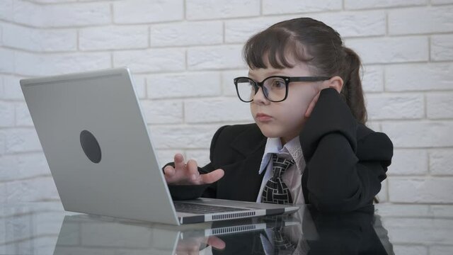 Unbelievable business. A little girl boss work on computer and feel amazed and very happy of her work.