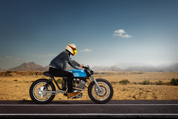 Fototapeta na wymiar Man seat on the motorcycle on the desert road.