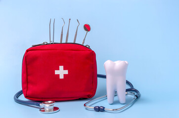 a model of a tooth, a stethoscope, a dentist's tool, a first aid kit. concept first aid for...