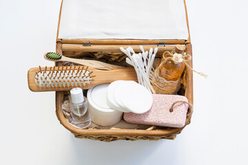 Top view of bathroom beauty set in wooden basket on white background. Self care, body care concept.