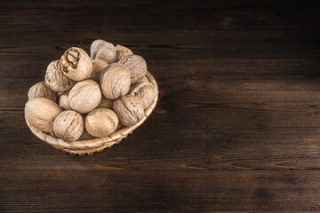 Walnuts on a dark wooden background, top view, copy space