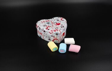 Heart-shaped gift box and candy with isolated background
