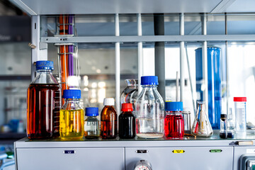 Closeup of laboratory glassware filled with various colored liquids, science and research background, selective focus