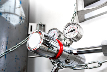 Closeup of pressure manometer measuring gas pressure, industry background, selective focus, pipes...
