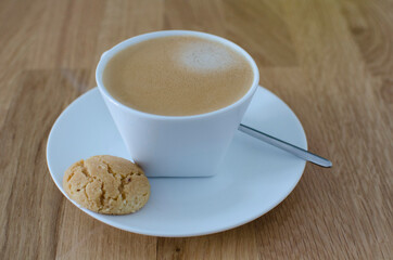 Morning cup of coffee with cookie wooden background