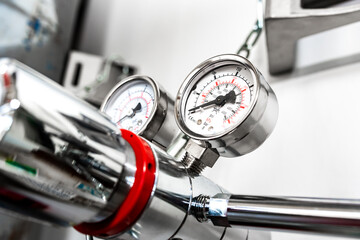 Closeup of pressure manometer measuring gas pressure, industry background, selective focus, pipes...
